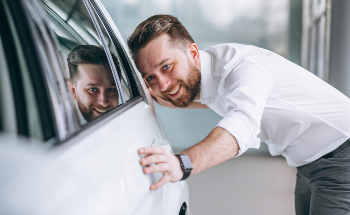 Business man buying a car in a showroom