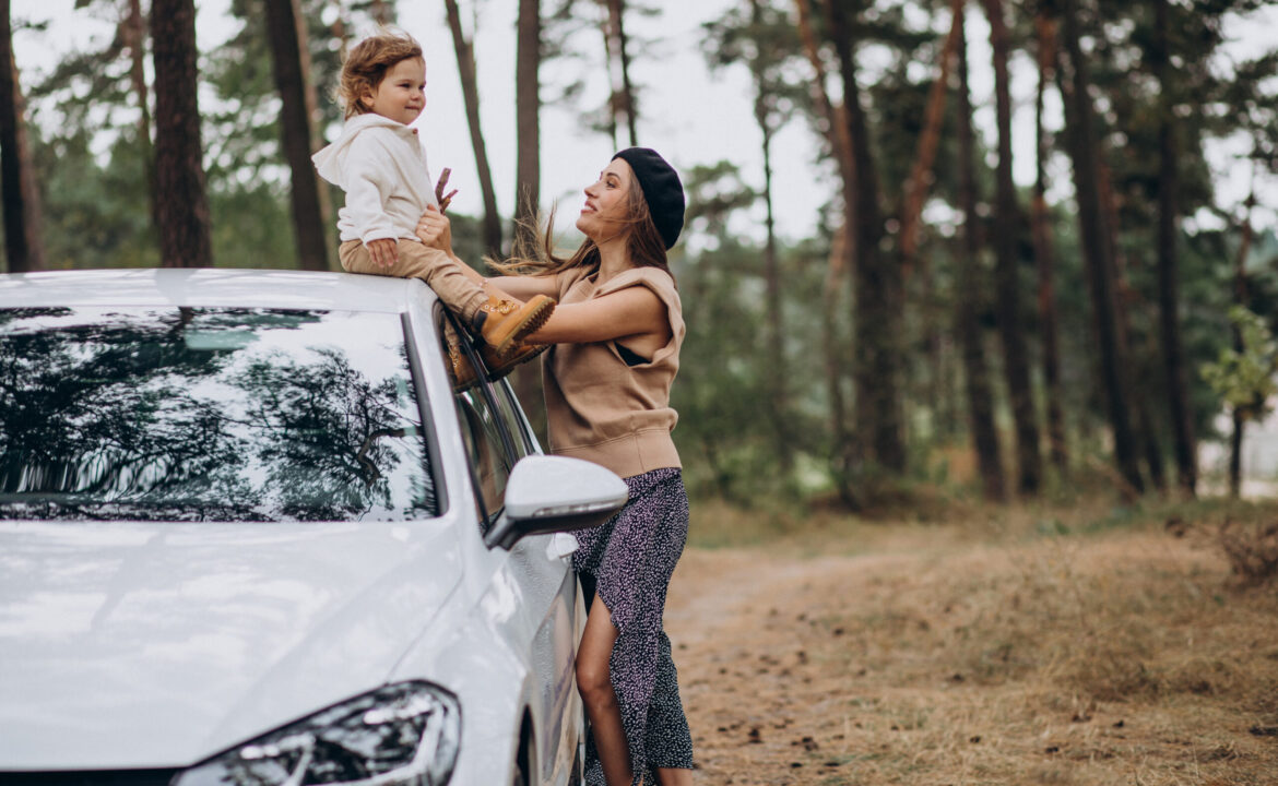 Mother with her son by the car in park