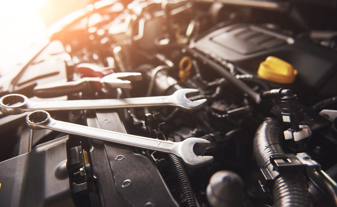 Mechanic hand checking and fixing a broken car in car service garage